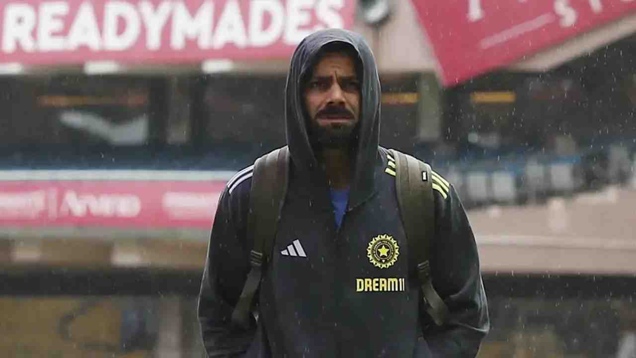 Virat Kohli looks on as the rain comes down